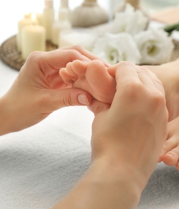 Des mains massent des pieds