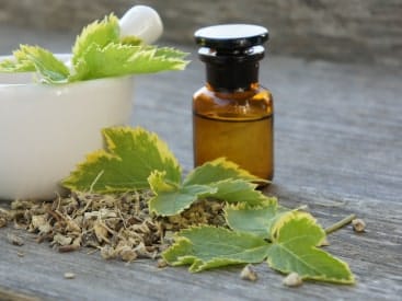 Flacon d'huile de plantes avec un bol à coté pour préparer l'huile